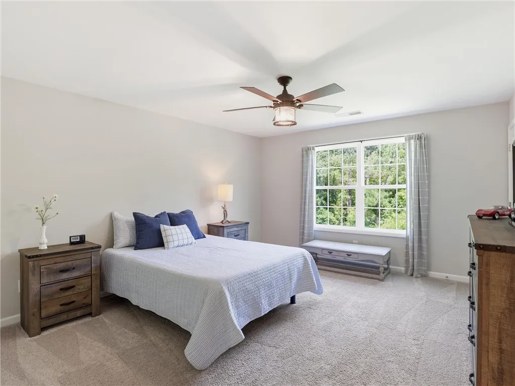 A tranquil bedroom provides comfort and a peaceful view of the outdoors.