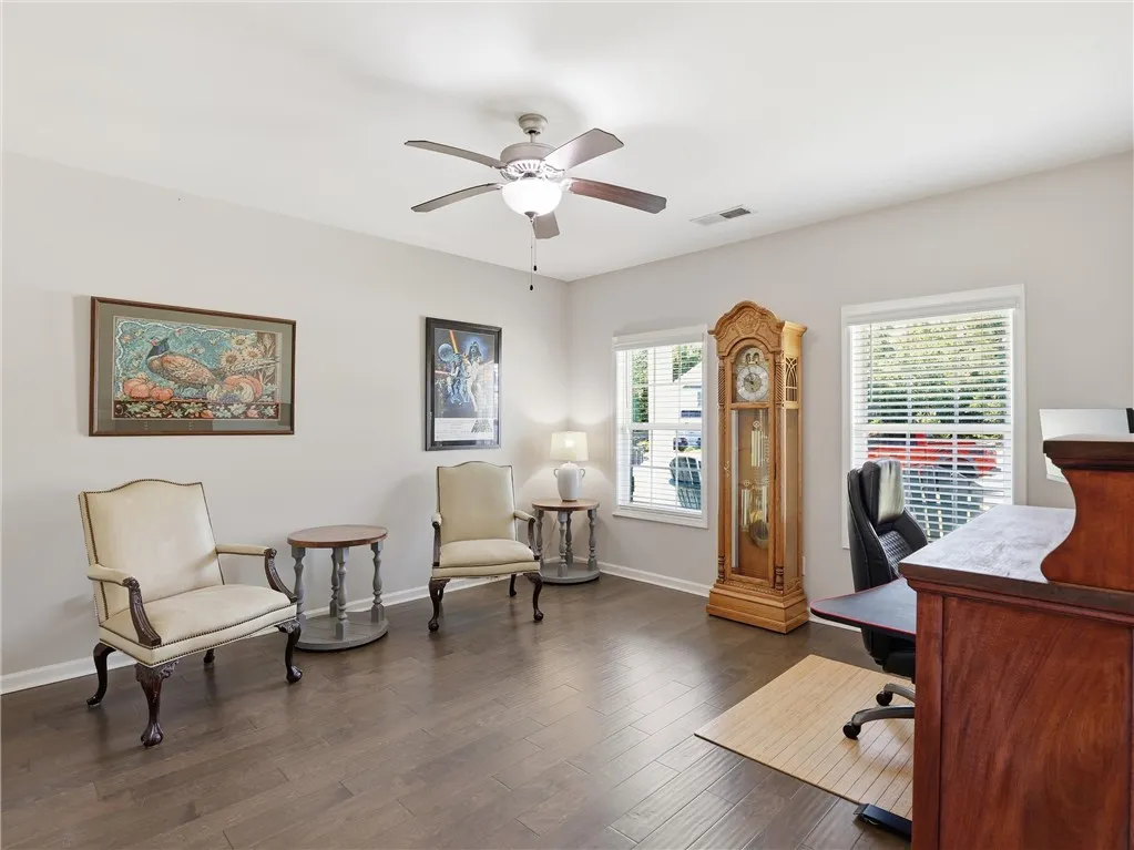Hardwood floors and generous natural light define this versatile room, perfect for a study or den.