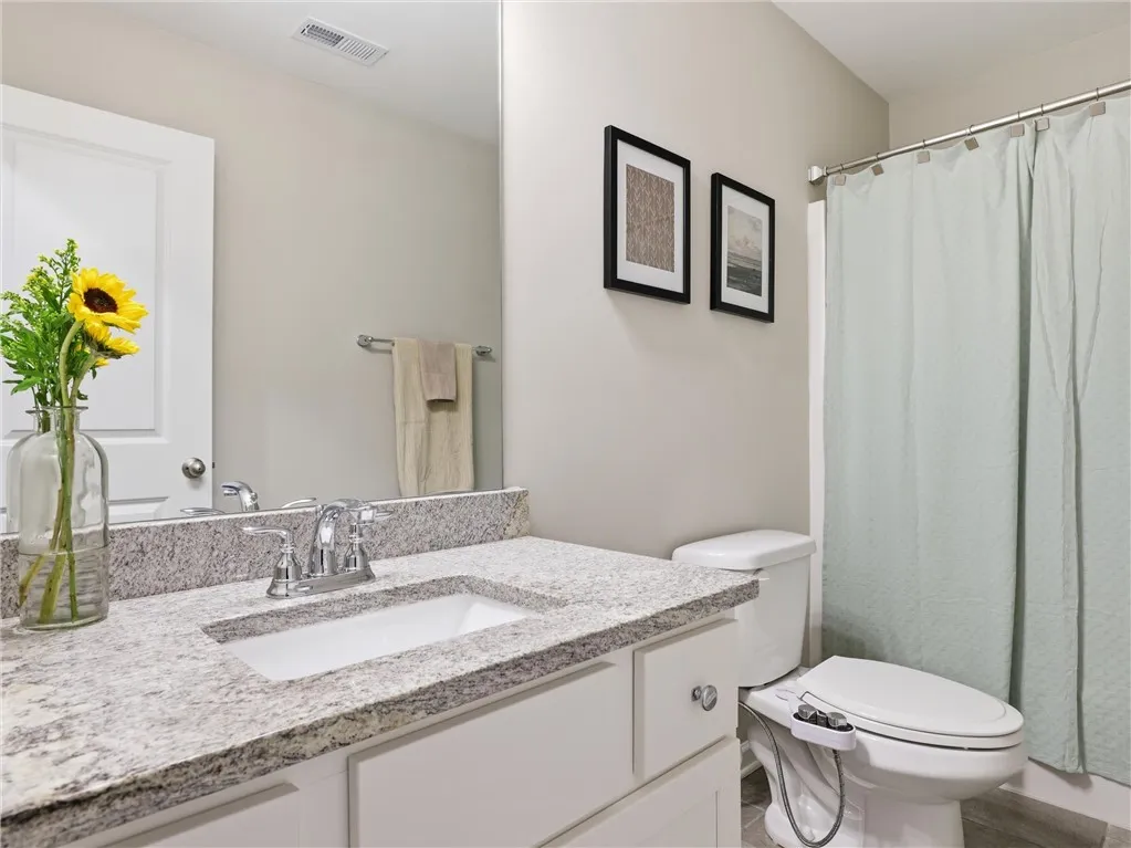 White cabinetry with granite counters in this well-appointed bathroom.