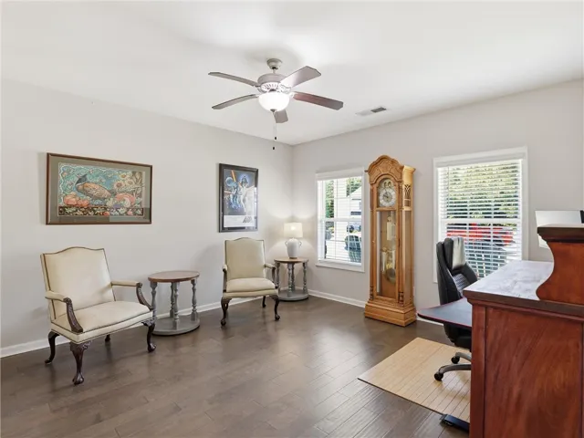 Hardwood floors and generous natural light define this versatile room, perfect for a study or den.