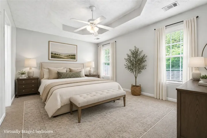 A spacious sleeping area with tray ceilings and plush carpeting.