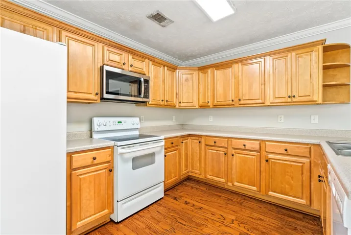 A well-equipped culinary space featuring warm wood cabinetry and durable countertops.