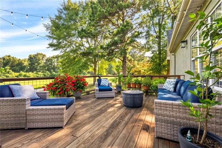 A spacious wooden deck provides ample outdoor living space, perfect for entertaining or quiet relaxation.