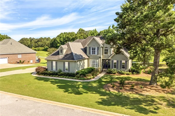 A classic exterior with a well-maintained yard and mature trees offers immediate curb appeal.