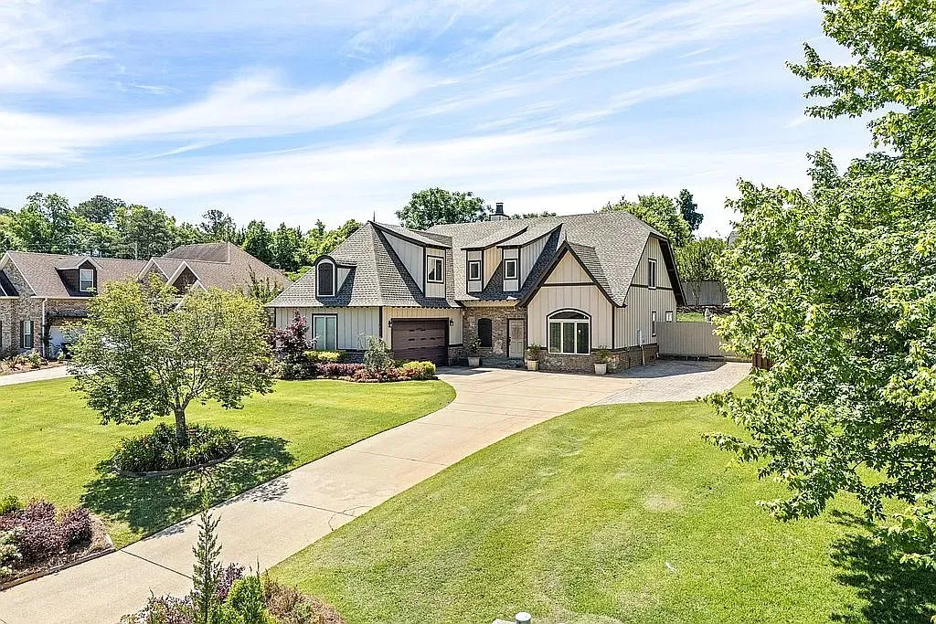 An inviting curved driveway leads to this charming two-story residence, framed by mature trees and manicured lawns.