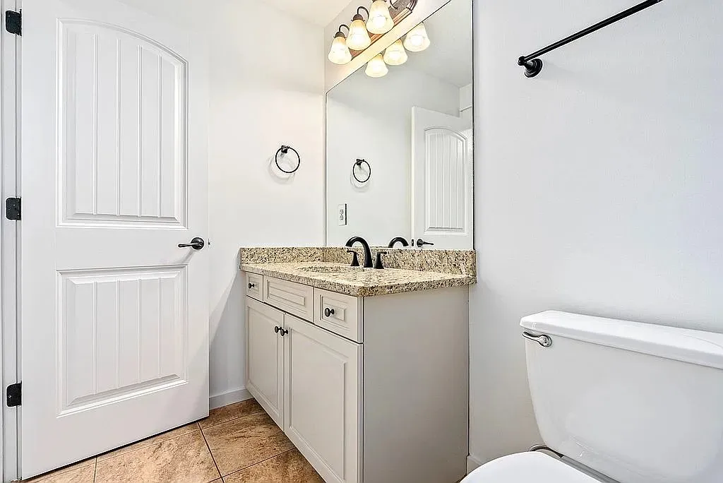 Granite counters and tile flooring accent this bright, well-appointed bathroom.
