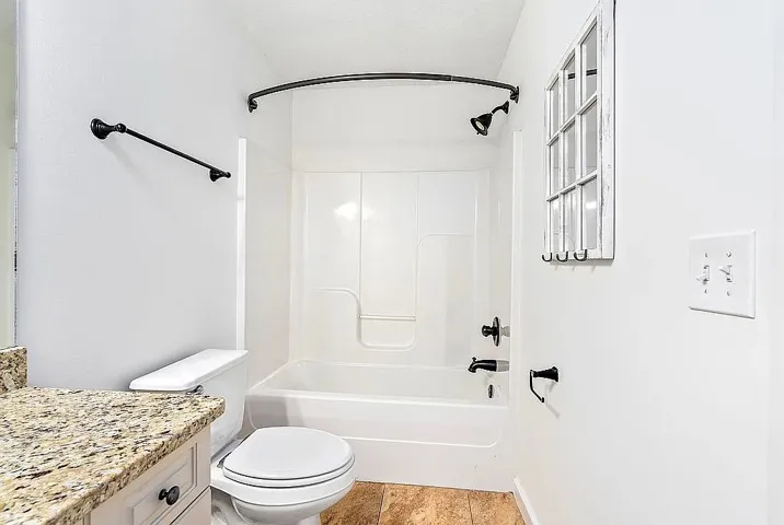 Tiled flooring and a practical shower-over-tub design define this well-appointed bathroom.