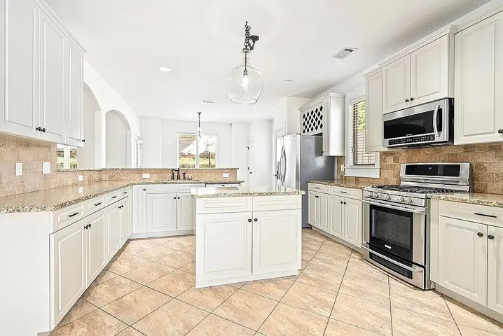 Culinary dreams come alive in this well-appointed kitchen featuring a functional island and premium appliances.