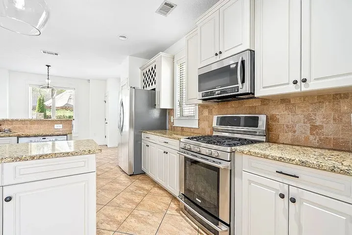 A well-appointed kitchen showcasing elegant granite counters and modern stainless steel appliances.