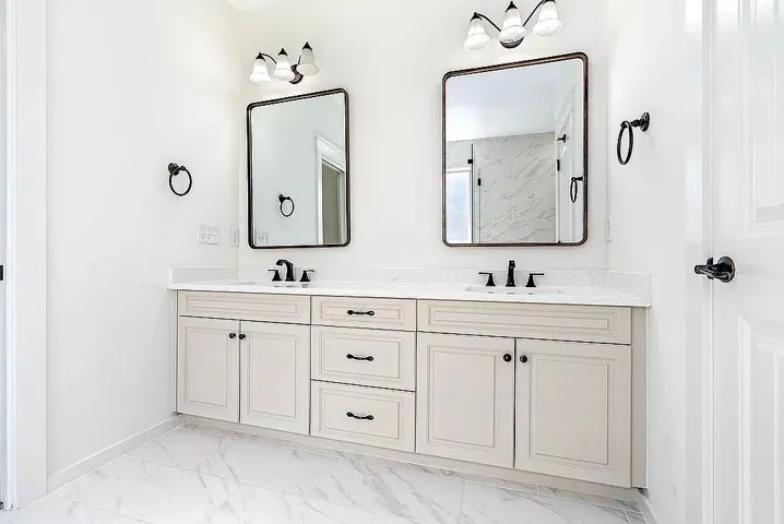Dual vanities with sleek countertops and mirrors offer a clean, elegant aesthetic.