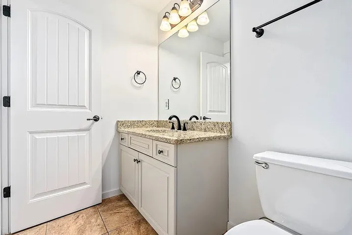 Granite counters and tile flooring accent this bright, well-appointed bathroom.