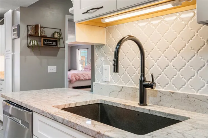 Premium granite countertops complement a modern black faucet, creating an inviting kitchen.