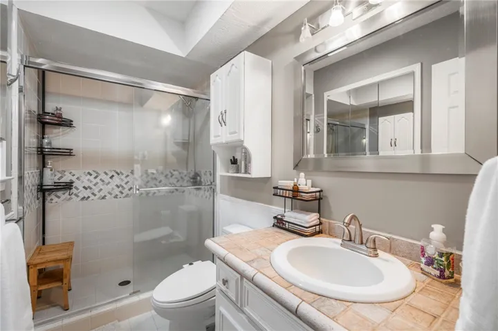 A well-appointed bathroom offers both a spacious shower with sleek glass enclosure and a practical vanity.
