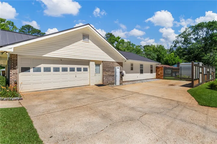 Ample parking and a two-car garage provide utility, framed by mature trees and verdant lawns.