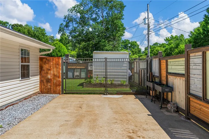 A well-maintained side yard features a sturdy fence and a convenient concrete patio.