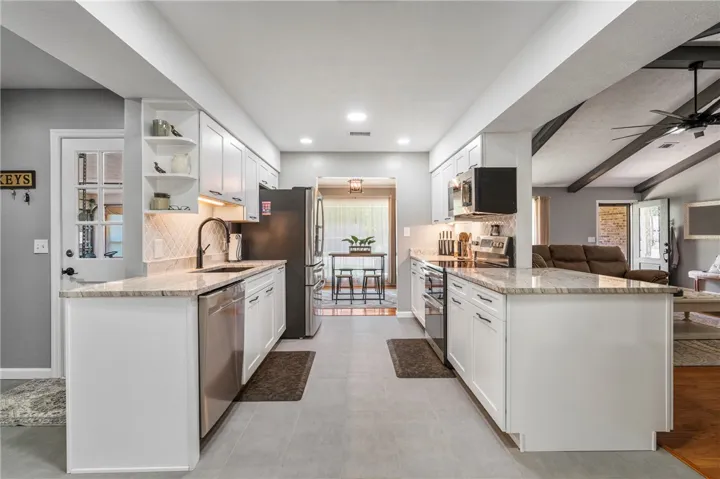 A galley kitchen with gleaming stainless steel appliances, abundant cabinetry, and a bright, open layout.