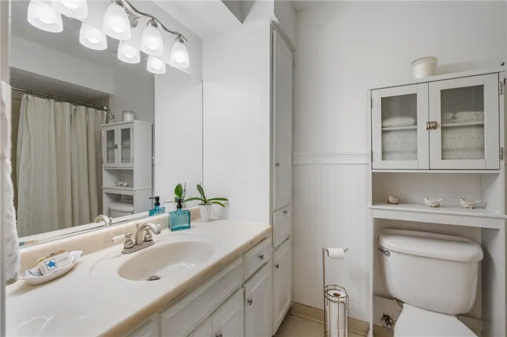 A well-appointed bathroom features ample storage and a broad vanity with integrated sink.