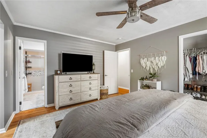 Hardwood floors and a ceiling fan create a comfortable and inviting atmosphere in this primary bedroom.