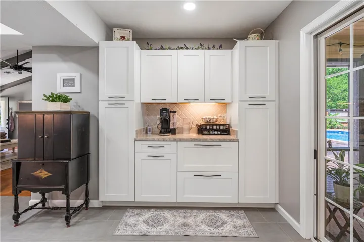 A well-appointed coffee bar with ample cabinetry and access to outdoor living.