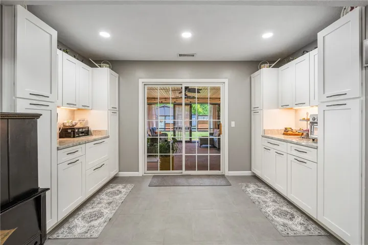 A well-appointed kitchen galley, boasting ample cabinetry and seamless outdoor access.