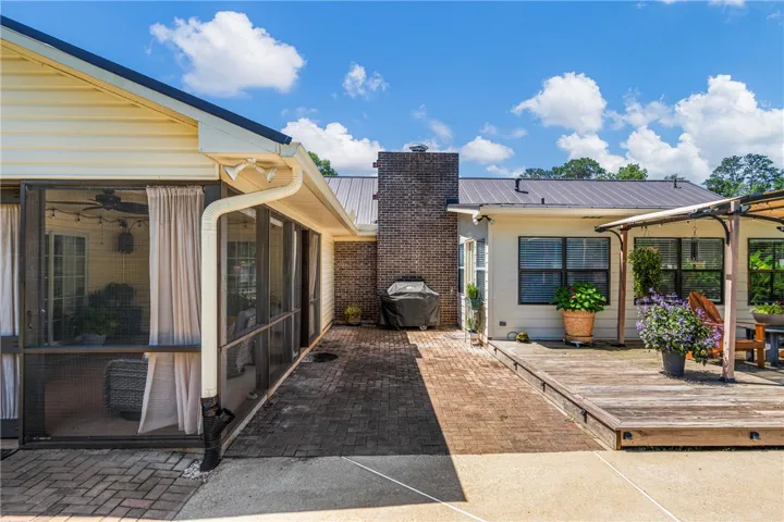 A screened porch and brick patio lead to a sun-drenched wooden deck, perfect for outdoor​​‌​​​​‌​​‌‌​‌‌​​​‌‌​‌​‌​‌​​​‌​​ enjoyment.