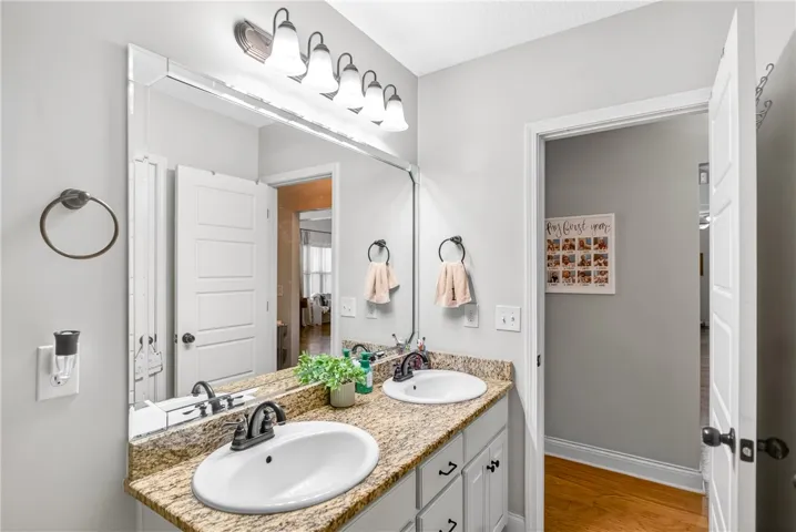 Granite counters and dual sinks provide ample space in this well-appointed bathroom.