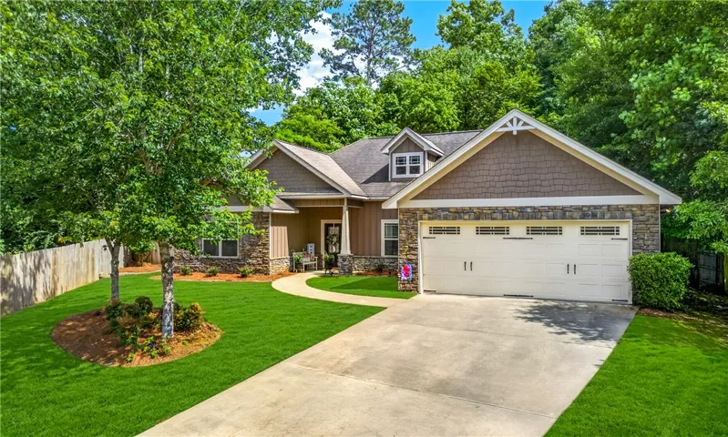 Crafted with elegant stone and shingle accents, this home boasts a welcoming front entry and a convenient attached garage.