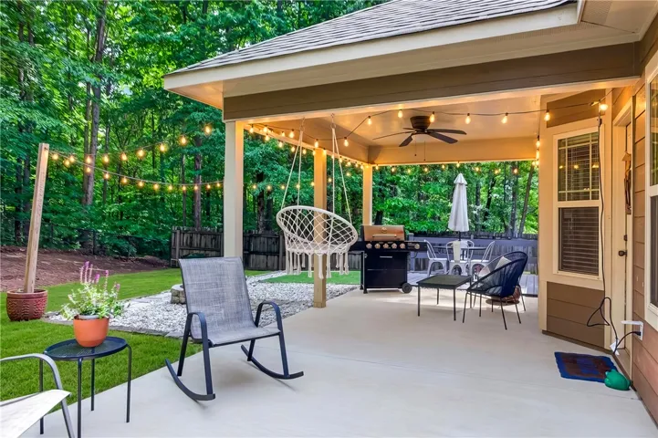Entertain guests on this covered patio, complete with ambient lighting, outdoor dining, and tranquil green views.