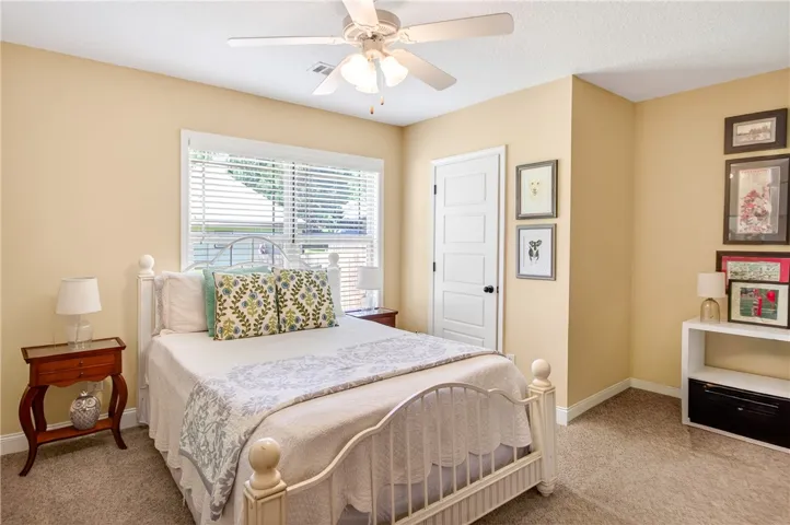 Well-lit sleeping quarters with plush carpeting and a convenient ceiling fan.