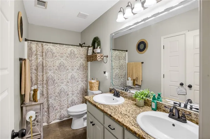 Granite counters with dual sinks enhance the functionality of this primary bath.