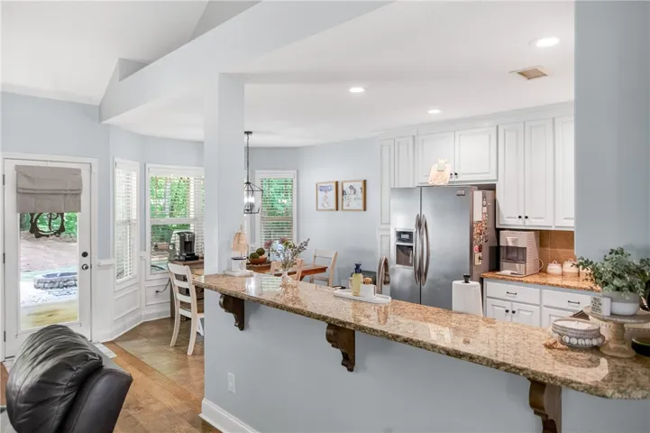 A vibrant kitchen with gleaming granite counters and abundant natural light offers comfortable living.
