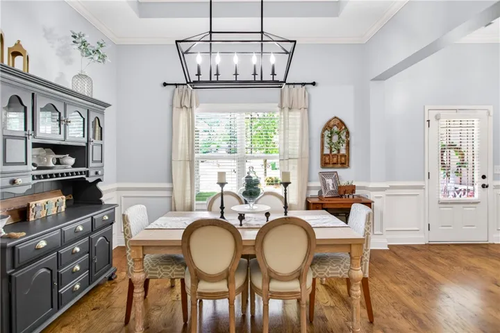 Hardwood floors and a sophisticated chandelier define this elegant dining room.