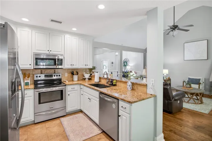 Culinary delights await in this bright kitchen, seamlessly flowing into a cozy living area, ideal for effortless entertaining.