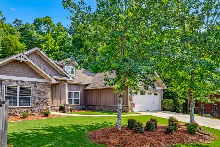 A welcoming abode boasts a combination of stone and siding for a charming facade.