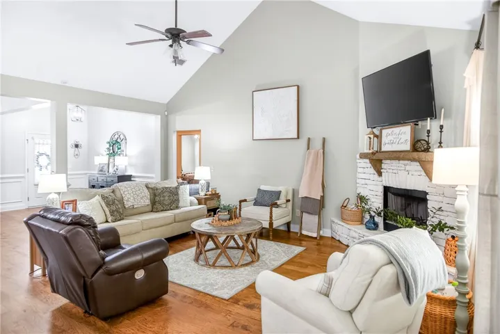 Enjoy the comforts of a spacious living room with soaring vaulted ceilings and a cozy fireplace, perfect for relaxation.
