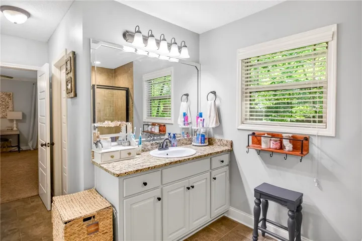 Granite counters and a spacious vanity create a functional and pleasant bathroom environment.