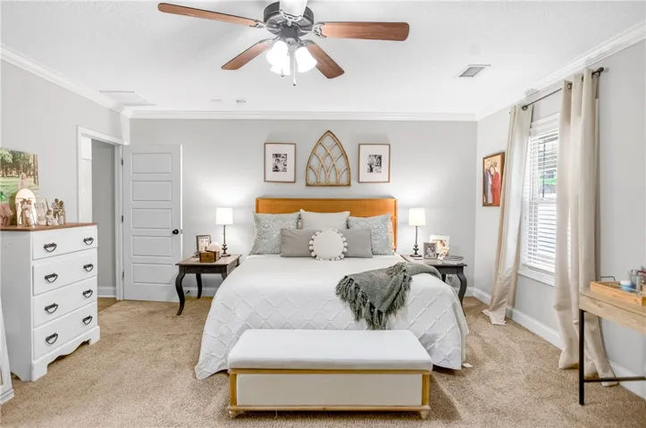 A comforting bedroom space featuring soft carpeting and a window for natural light.