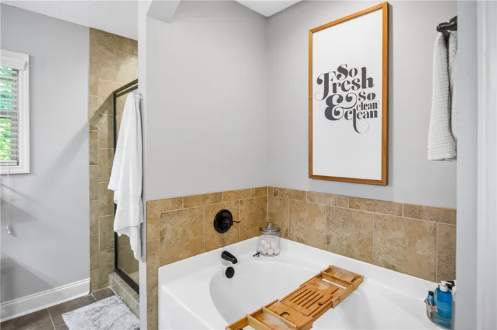 Indulge in relaxation with this inviting soaking tub and tiled shower.