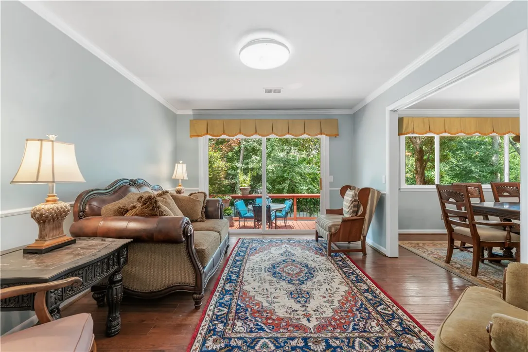 Bright hardwood floors and abundant natural light illuminate this welcoming gathering space with a private deck beyond.