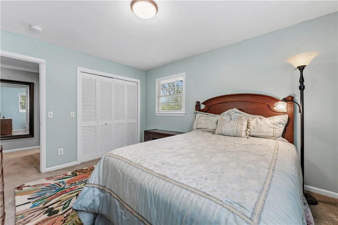 A comforting retreat awaits, complete with soft carpets and a classic wooden bedframe.