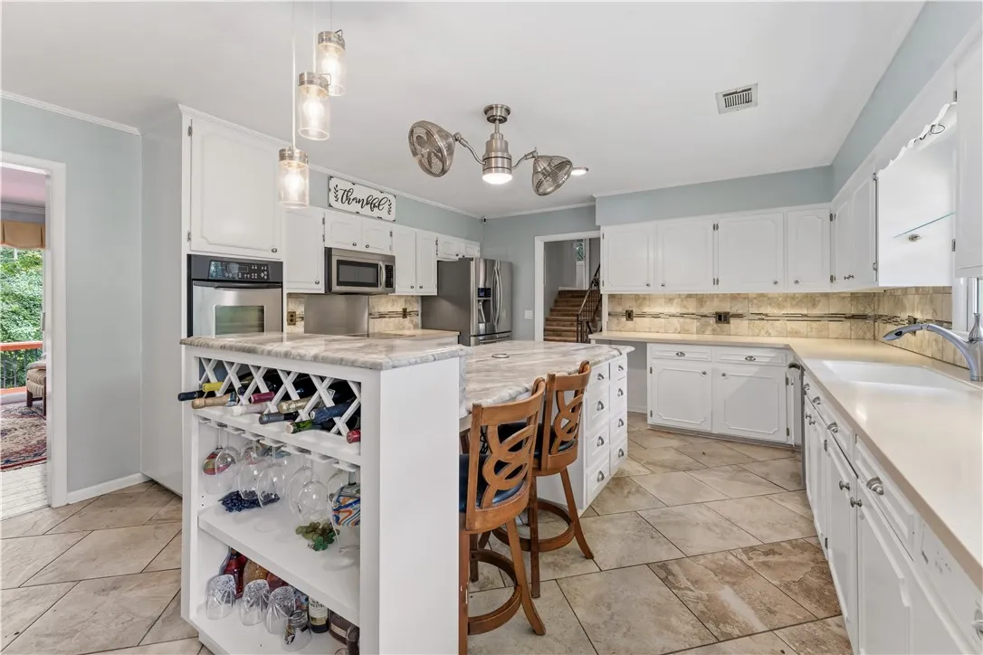 Culinary delights await in this bright kitchen with a spacious island, built-in wine storage, and ample counter space.