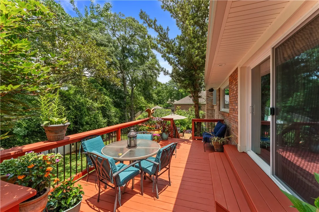 An inviting deck, surrounded by mature trees, provides ample space for outdoor relaxation and entertaining.