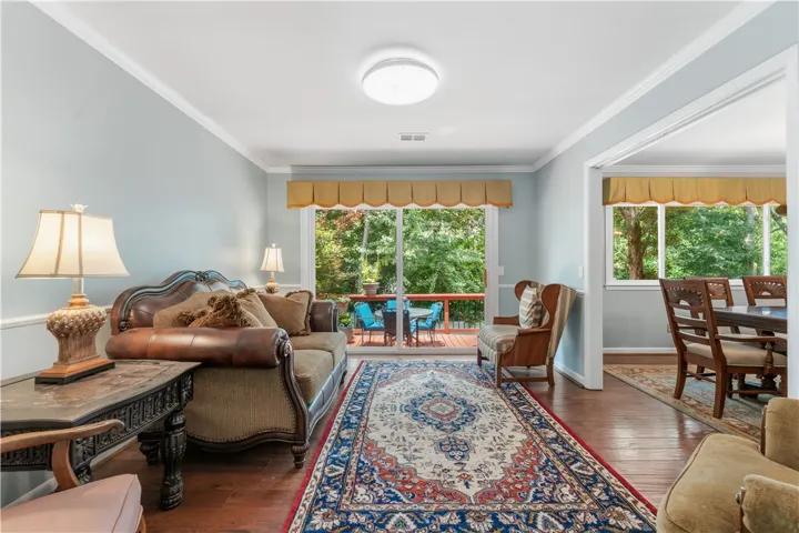 Bright hardwood floors and abundant natural light illuminate this welcoming gathering space with a private deck beyond.