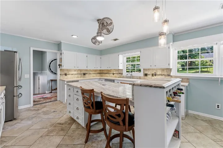 Culinary adventures await in this kitchen, boasting an island with seating and garden views.