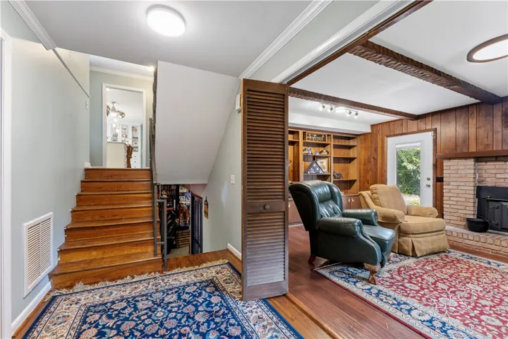 Rich hardwood flooring complements the exposed beam ceiling in this comfortable family room.