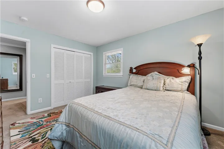 A comforting retreat awaits, complete with soft carpets and a classic wooden bedframe.