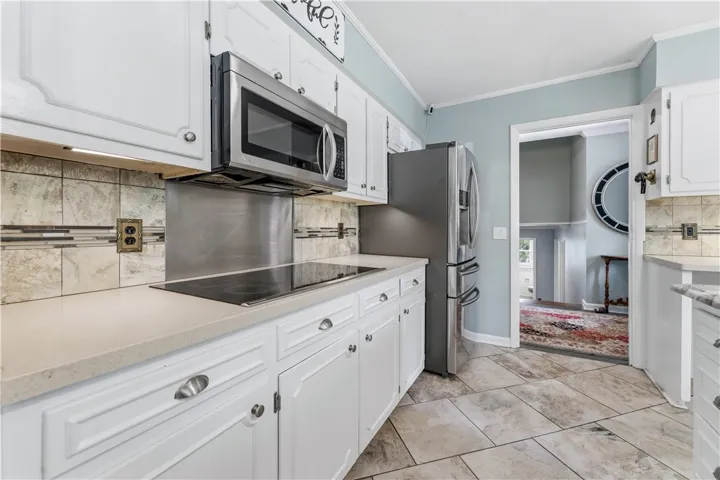 Bright, white cabinetry and stainless steel appliances elevate this kitchen's timeless appeal.