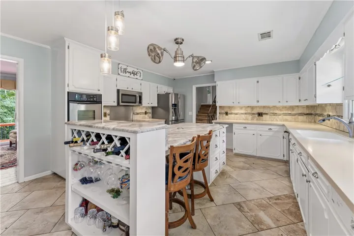 Culinary delights await in this bright kitchen with a spacious island, built-in wine storage, and ample counter space.