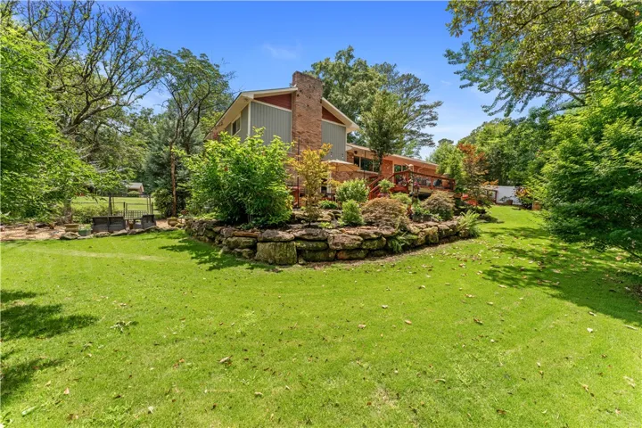 Mature trees and terraced landscaping create a secluded outdoor haven surrounding this charming residence.
