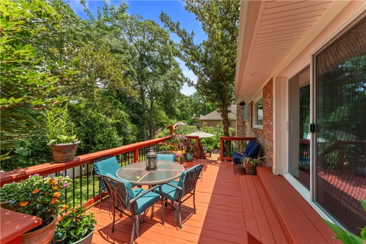 An inviting deck, surrounded by mature trees, provides ample space for outdoor relaxation and entertaining.
